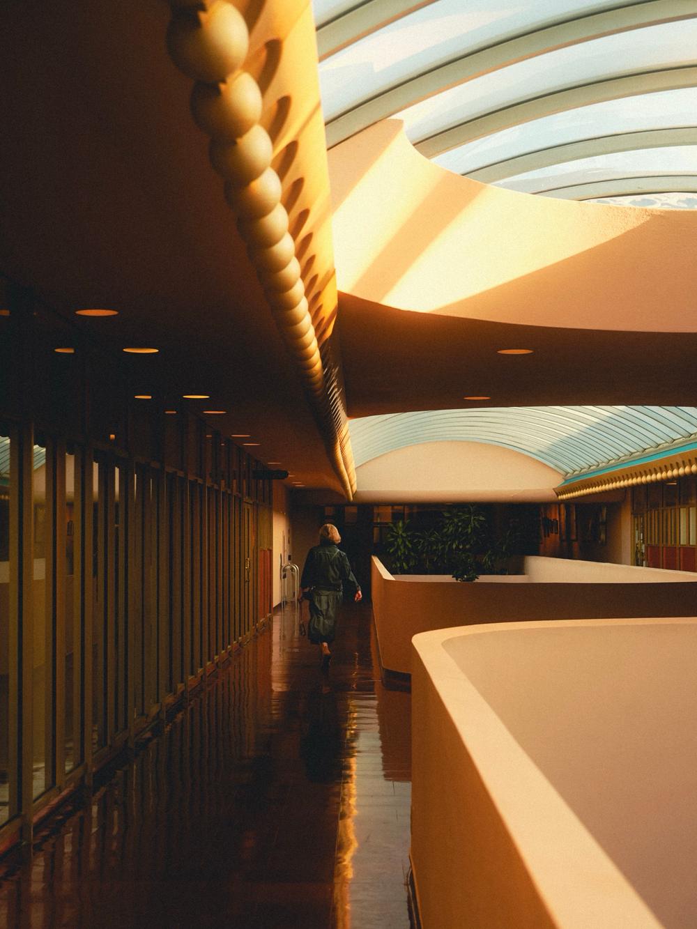 A person walking through the curved interior of the Marin County Civic Center